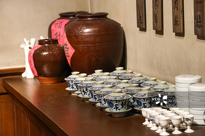 传统酒店场景：案台上的酒缸与茶杯餐具图片素材