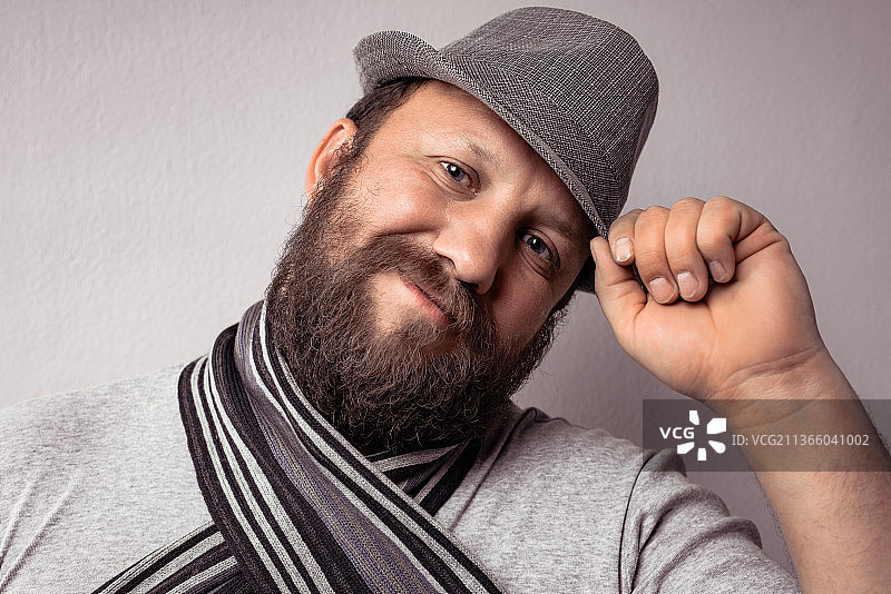 戴灰色帽子和围巾的年轻胡子男图片素材
