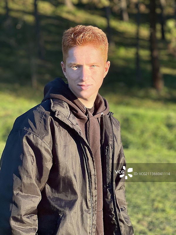 眼睛漂亮的红发男人，站在田野上的年轻男人肖像，西班牙巴塞罗那图片素材