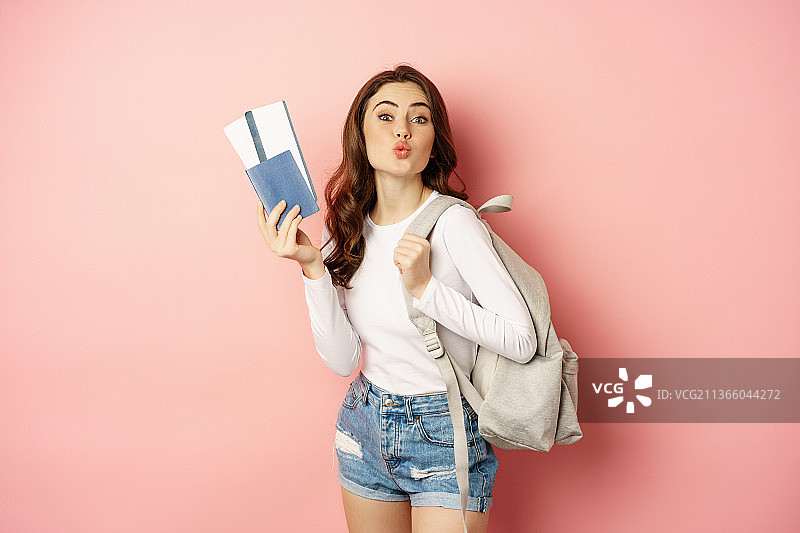 度假中的美丽女孩，拿着护照和机票准备旅行图片素材