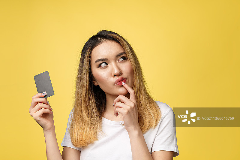 年轻微笑的亚洲女人手持信用卡图片素材