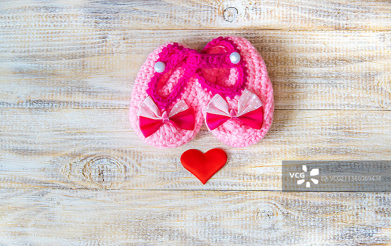 浅色背景下的婴儿短靴和心形，选择性聚焦图片素材