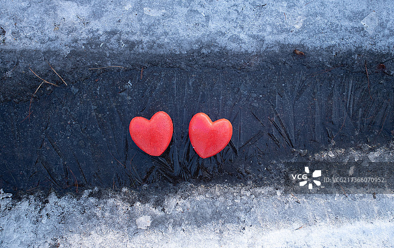 冰面上的两颗红色心形，俯视，横版照片图片素材