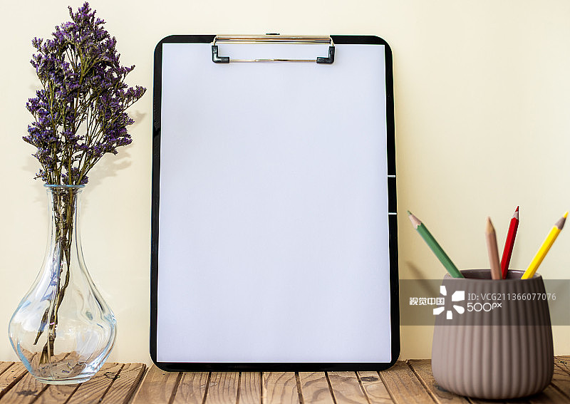 花旁边的笔筒里放着一堆笔的普通办公剪贴板图片素材