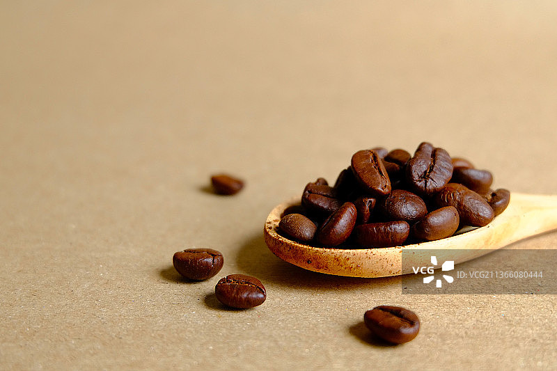 木勺中的咖啡豆，桌上烘焙咖啡豆特写图片素材