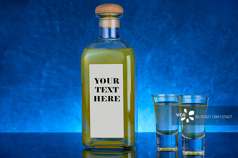 黄色利口酒瓶，蓝色背景和标签，带文案空间图片素材