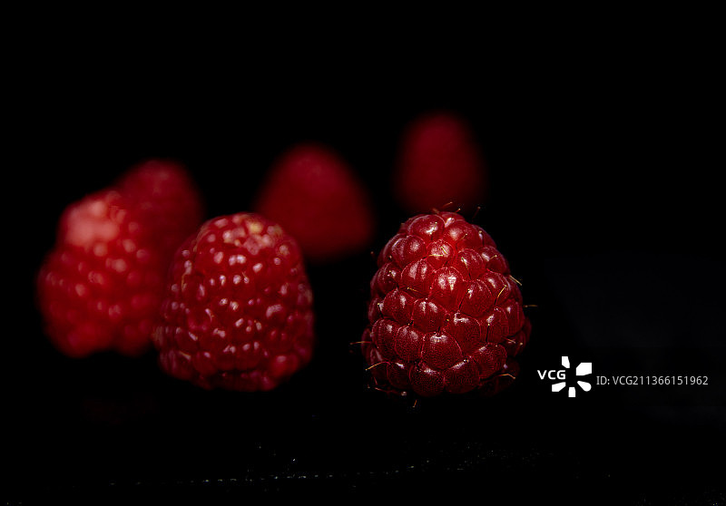 黑色背景下的覆盆子特写图片素材