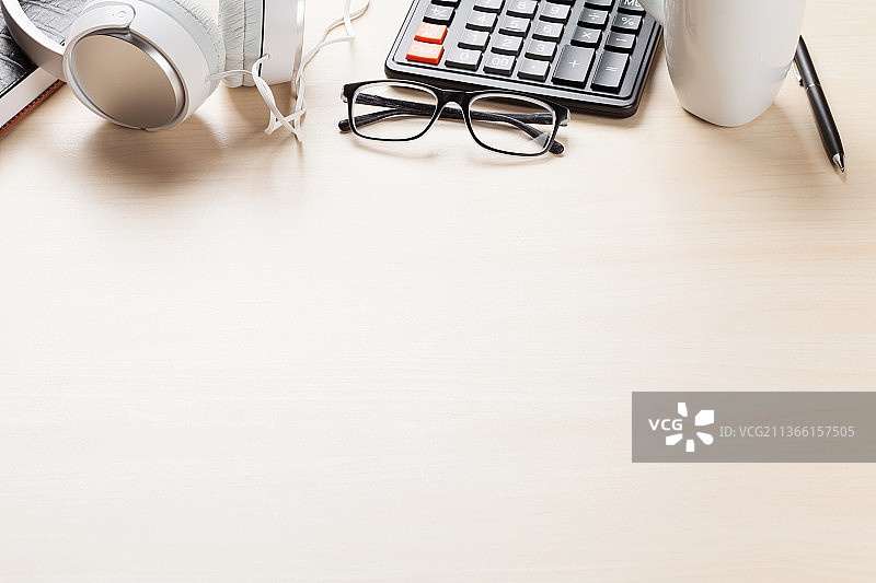 配有咖啡杯、记事本和耳机的办公桌图片素材