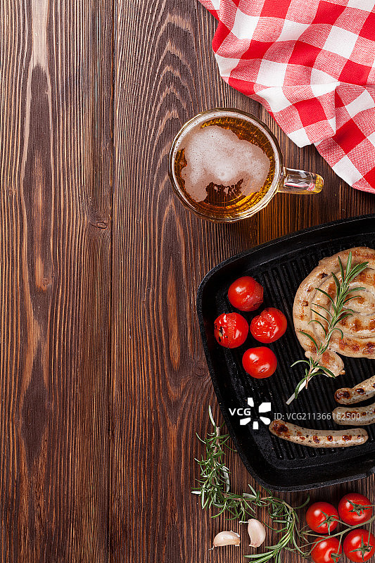 烤香肠和啤酒杯，餐桌上的食物俯视图图片素材