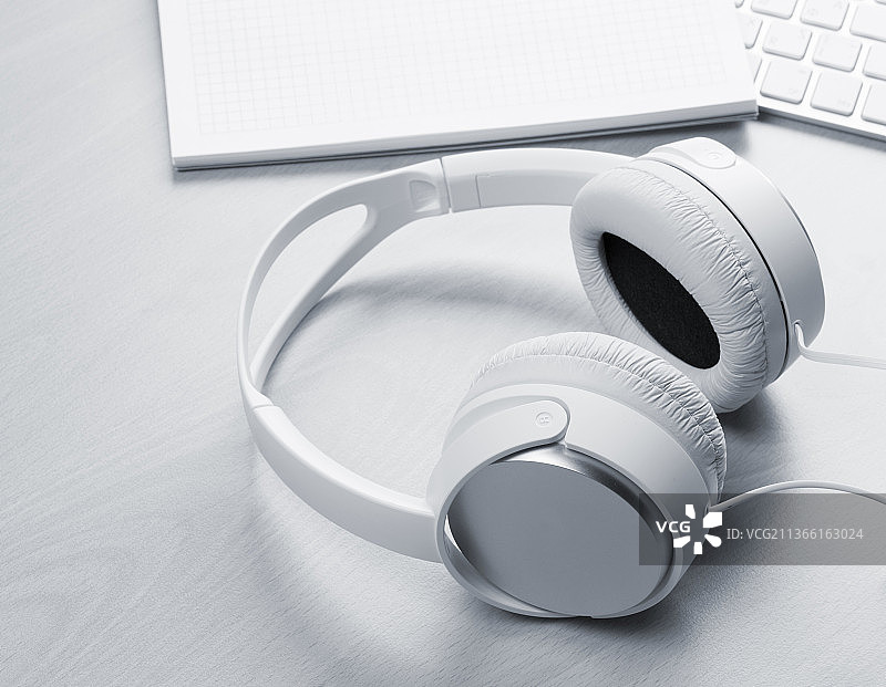 耳机、记事本和电脑，桌子上耳机的高角度视图图片素材