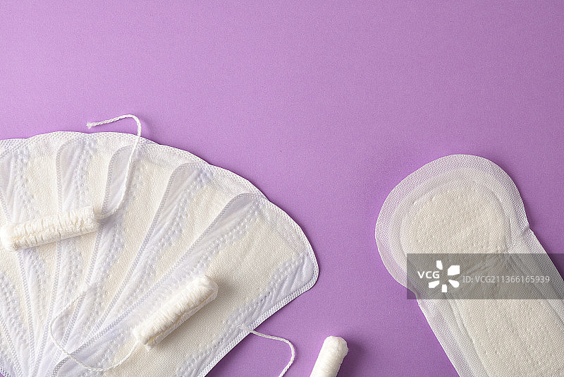 丁香背景上的女性月经棉塞和卫生巾包顶部图片素材