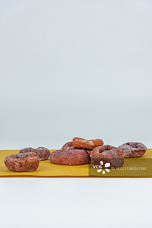 棕色牛皮纸上摆放的橙色柿饼图片素材