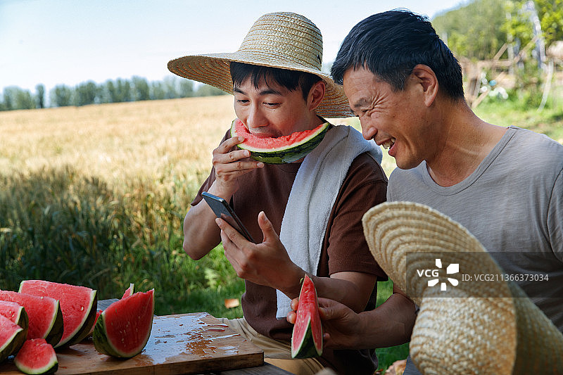 农民在田地旁休息吃西瓜图片素材