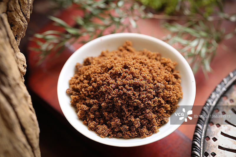 树旁红色桌上的一碗红糖粉图片素材