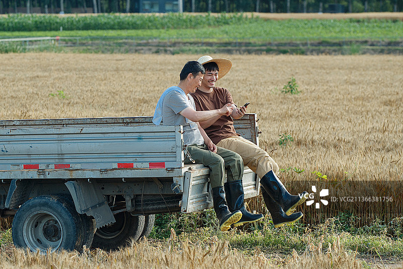 坐在车上使用手机的农民图片素材