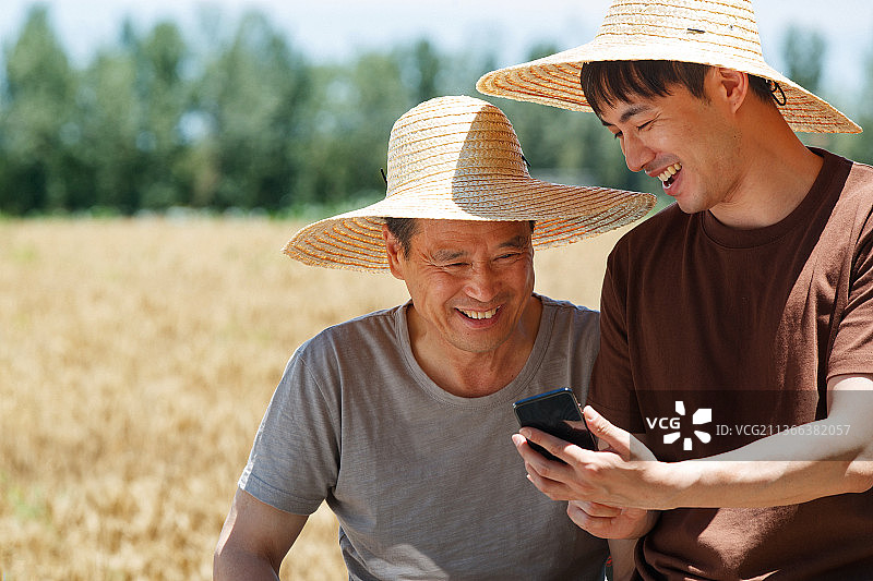 农民坐在三轮车上使用手机图片素材