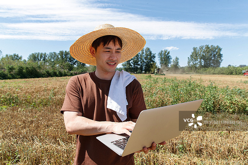 科研人员站在田地旁使用电脑图片素材