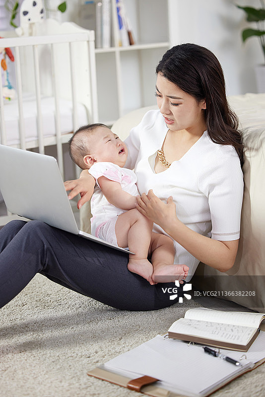 带着宝宝工作的年轻妈妈图片素材