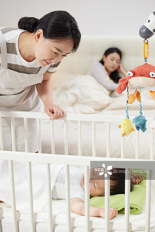 月嫂照看宝宝睡觉图片素材