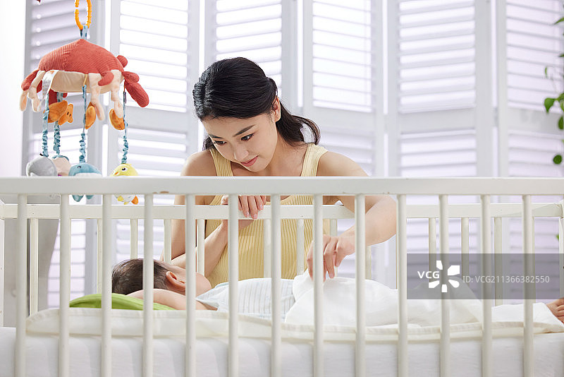 年轻妈妈陪伴宝宝睡觉图片素材