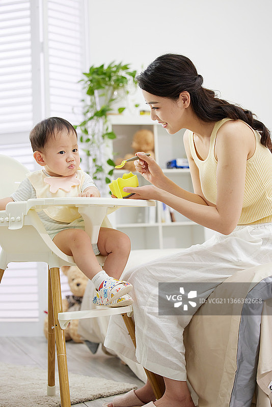 年轻妈妈喂宝宝吃饭图片素材