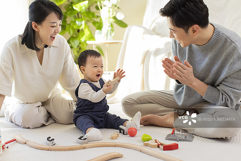 年轻父母在家陪宝宝玩耍图片素材