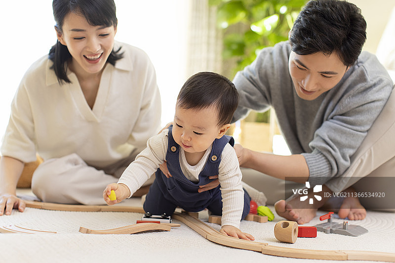 年轻父母在家陪宝宝玩耍图片素材