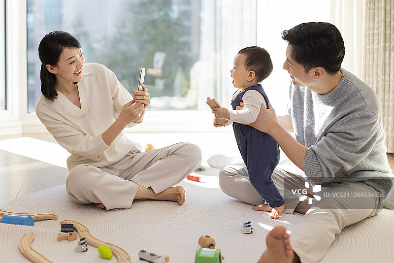 年轻父母在家陪宝宝玩耍图片素材