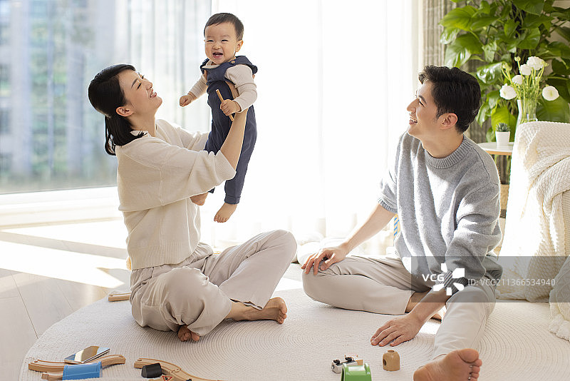 年轻父母在家陪宝宝玩耍图片素材