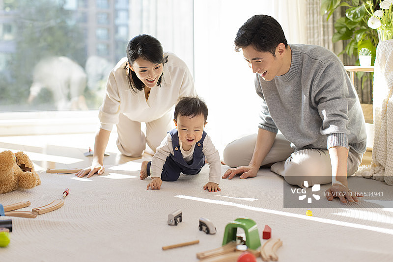 年轻父母在家陪宝宝玩耍图片素材