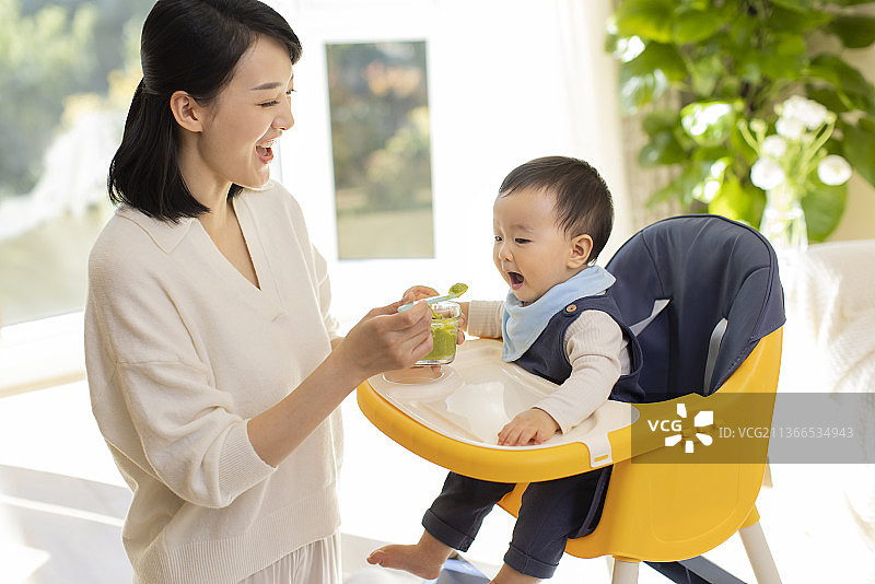 年轻妈妈给宝宝喂食图片素材