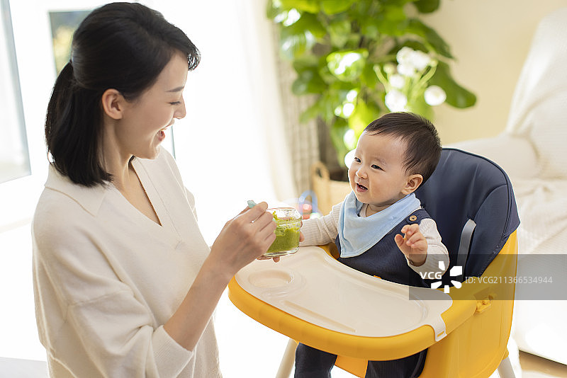 年轻妈妈给宝宝喂食图片素材