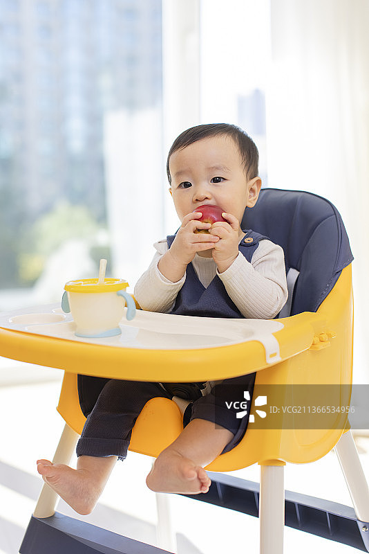 可爱的宝宝坐在儿童餐椅里图片素材