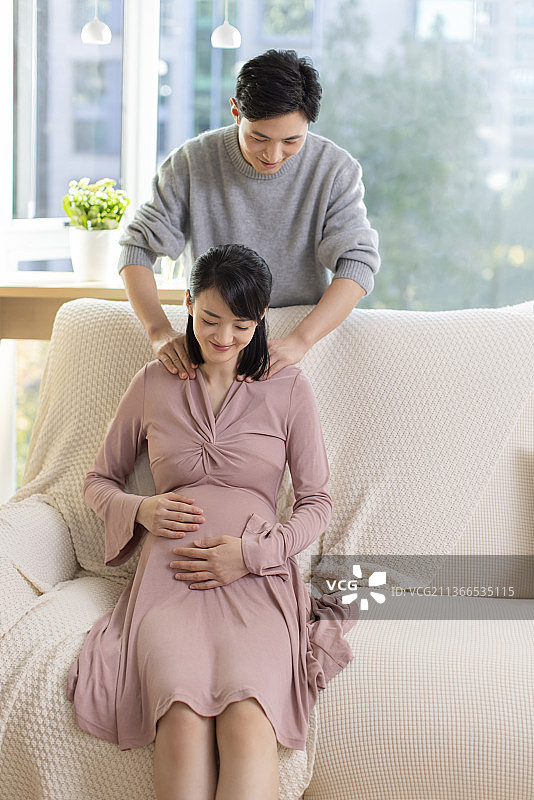 年轻丈夫在家照顾怀孕的妻子图片素材