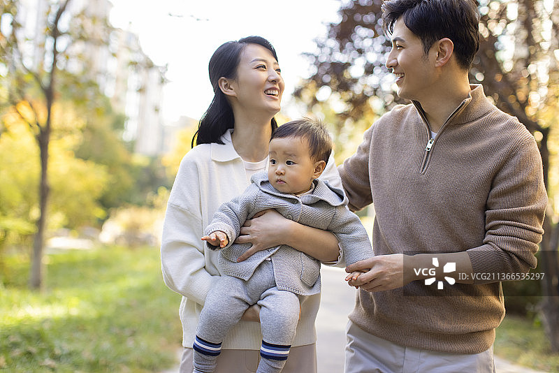 年轻父母在公园陪宝宝玩耍图片素材