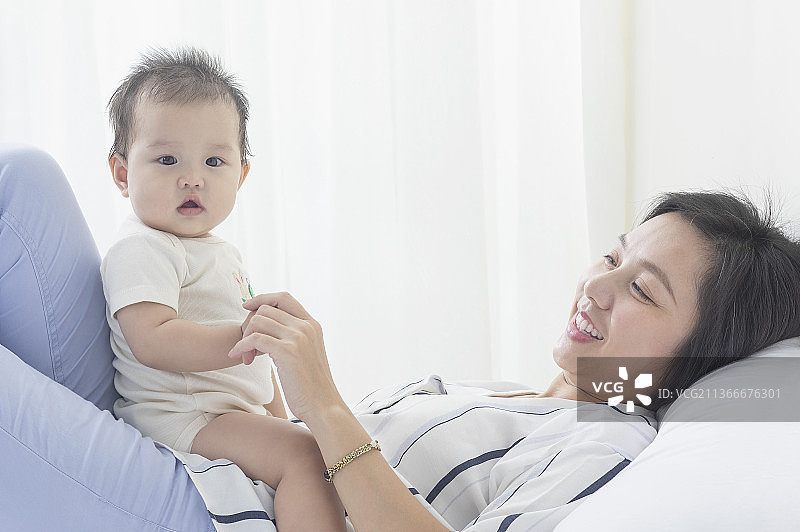 妈妈躺在床上和宝宝玩耍图片素材