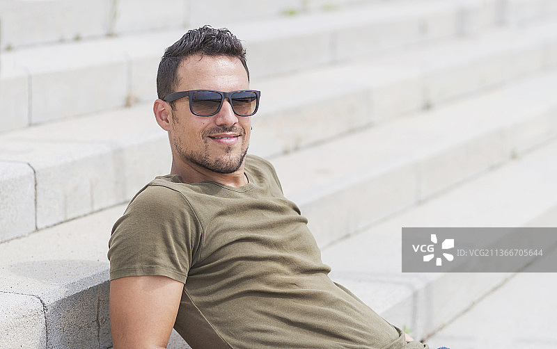 男人独自坐在台阶上，戴着太阳镜图片素材