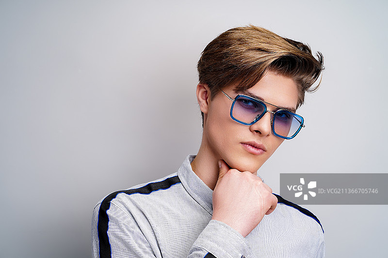 戴着时尚眼镜的年轻男子看着镜头图片素材