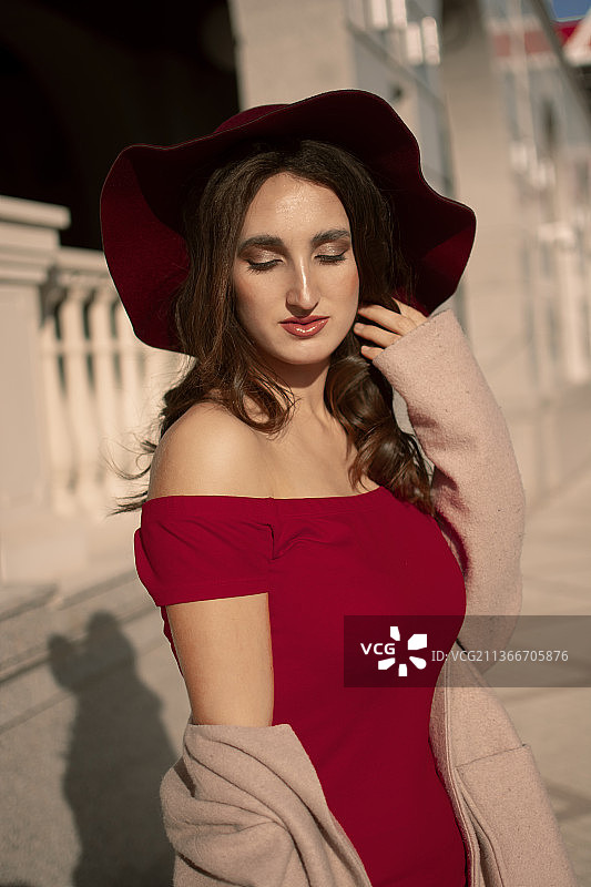 身穿红色连衣裙和帽子的年轻女孩在摩尔多瓦城市漫步图片素材