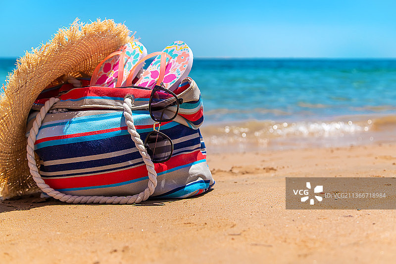在海滩上放松的包和物品，选择性聚焦图片素材