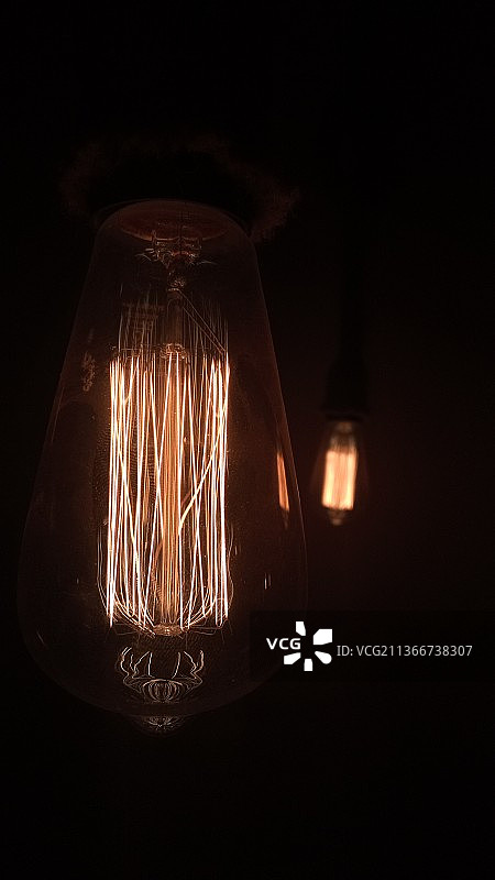 黑色背景下发光灯泡特写图片素材