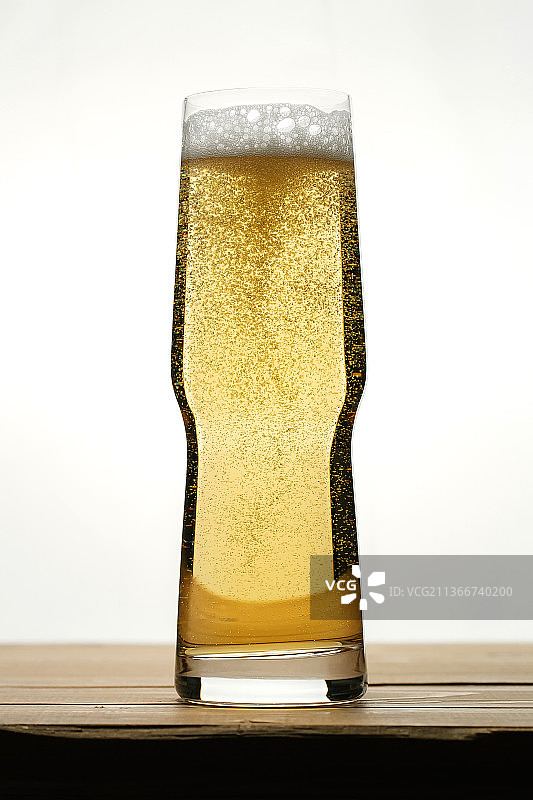 透明玻璃杯中带气泡的金色啤酒图片素材