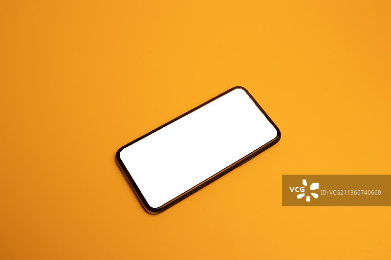 黄色背景上旋转的智能手机模型图片素材