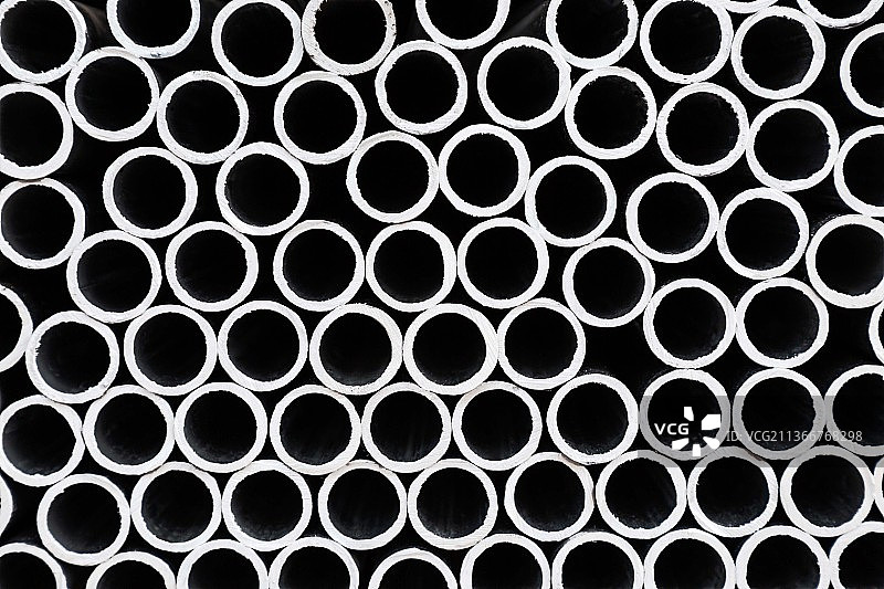 层叠堆积摆放的金属管道的圆形横截面图片素材