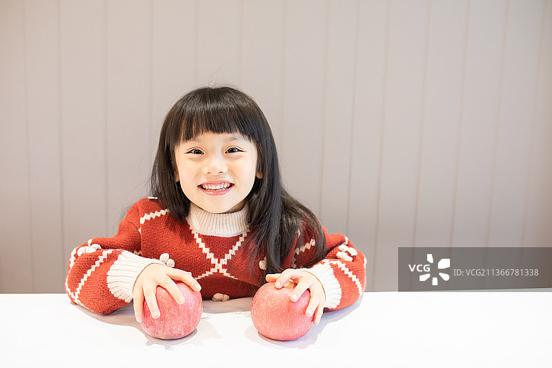 穿红毛衣玩苹果的小女孩图片素材