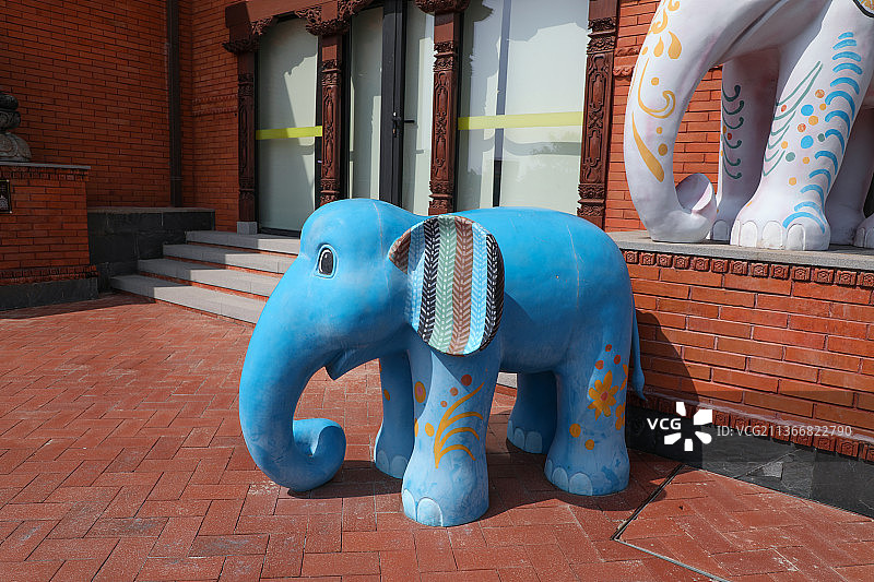 红色建筑前的彩色大象雕塑图片素材