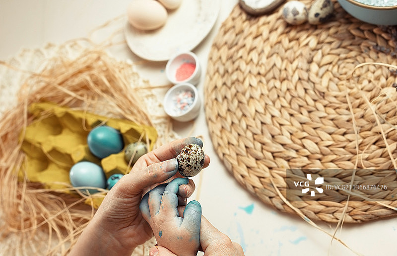 女人帮助她的孩子染复活节彩蛋图片素材