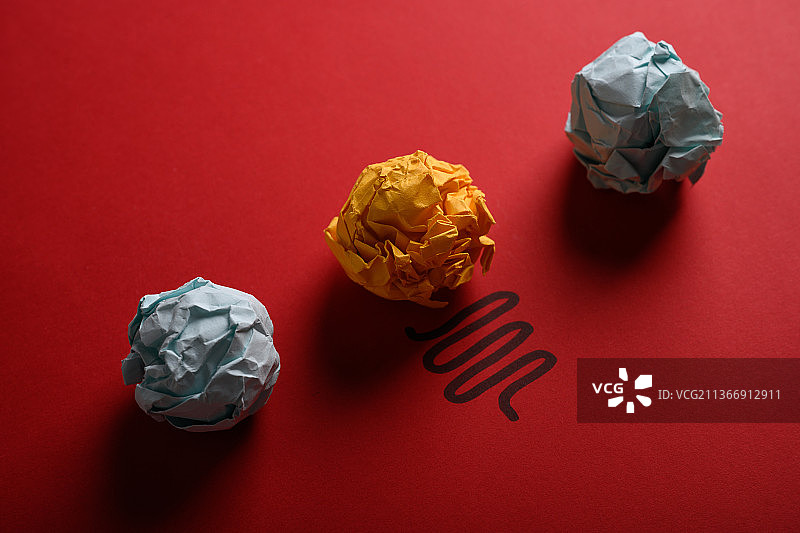 红色背景上的创意纸团灯泡图片素材