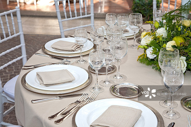 为招待会设置的优雅餐桌，餐桌上的座位设置高角度视图，意大利图片素材