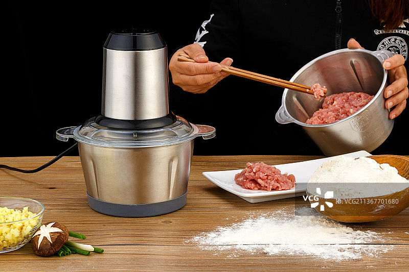 制作肉馅的桌面上放着绞肉机和面粉碎菜料理机图片素材